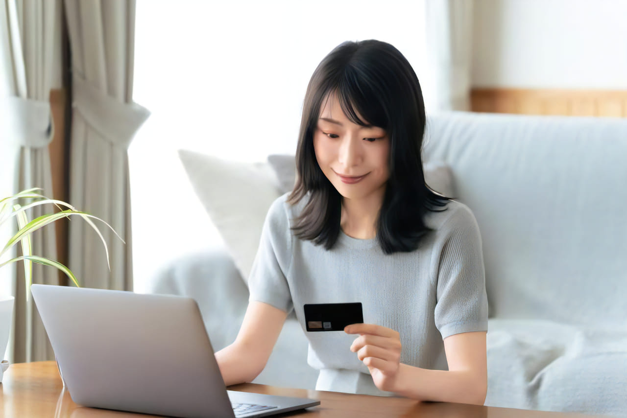 クレジットカードをみる女性